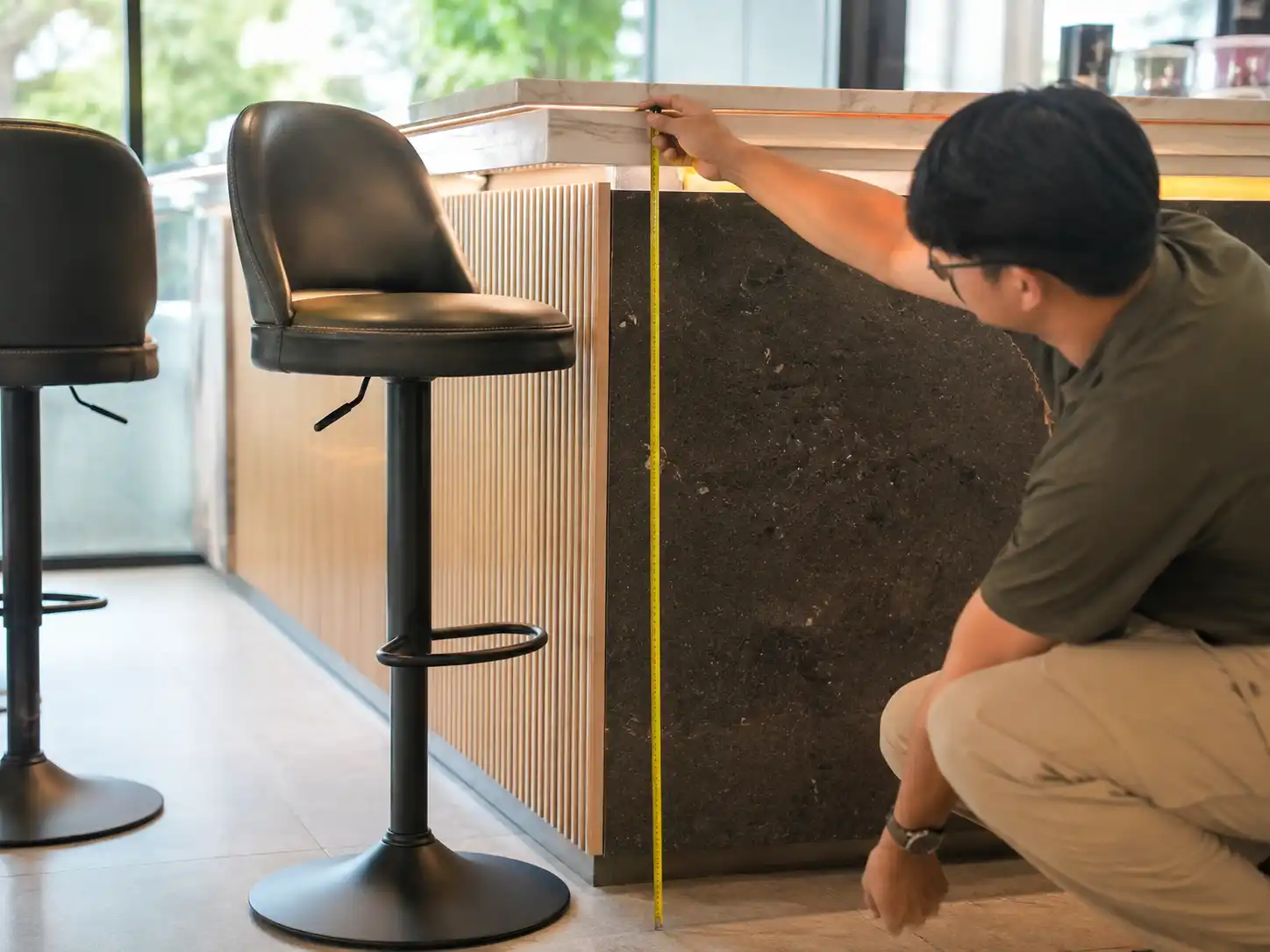 Measuring counter height before confirming a bulk bar stool order