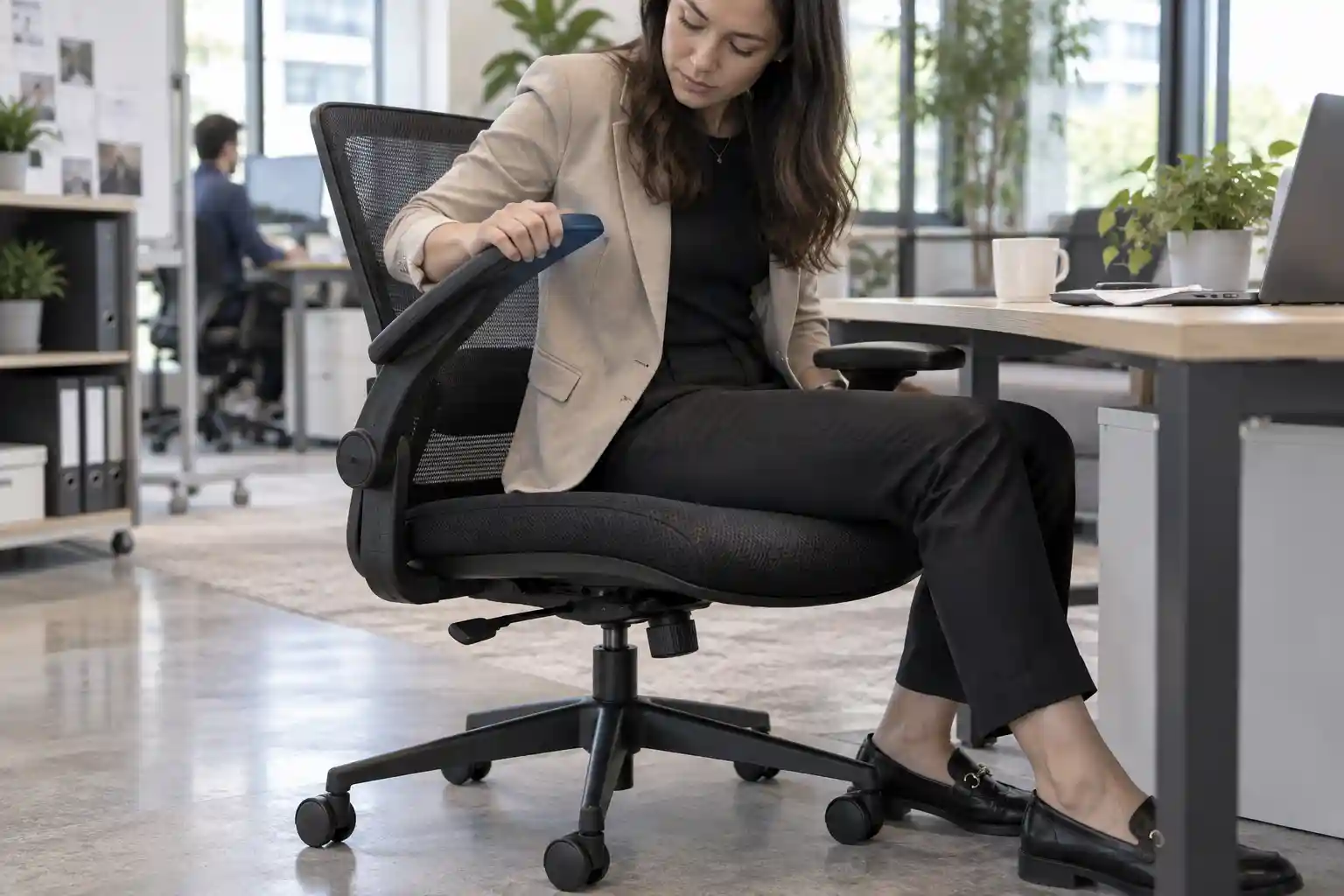 Buyer testing armrests lumbar support and height adjustment on a mesh office chair sample